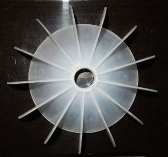 A white plastic fan on top of a table.