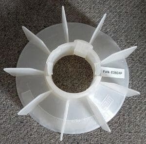 A white plastic fan with a label on it.